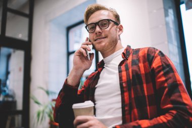 Kafedeki telefona sıcak içecek taşıyan adam cevap veriyor.