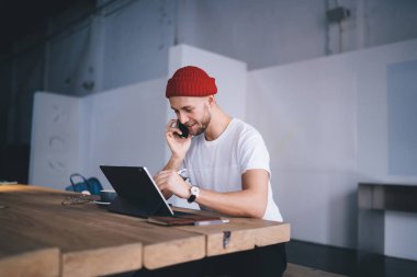 Başarılı bir adam, ressamlar için çizim tabletine Stylus kalemle resim çizerken cep telefonu uygulaması üzerinden arkadaşına telefon eder. Uzaktan çalışma için dokunmatik ped kullanan pozitif hipster adam.