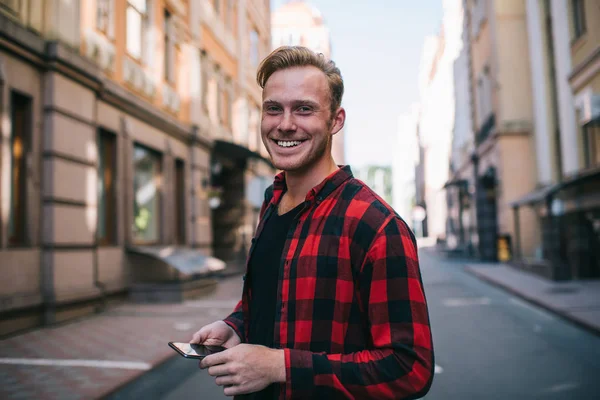 Cheerful man using smartphone on street — Stock Photo, Image