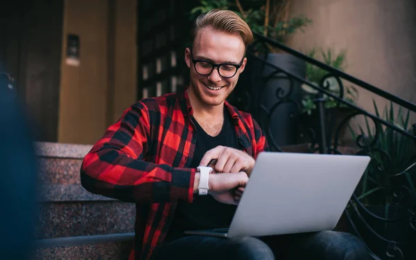 Homem alegre com laptop verificando notificações — Fotografia de Stock