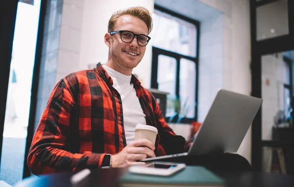 Freelancer sorrindo com bebida no café — Fotografia de Stock