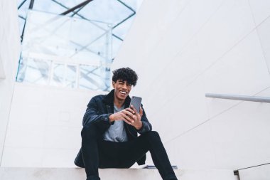 Latin hippi çocuk, sosyal ağda kendi web günlüğü için iyi yorumlar ve eleştiriler almaktan mutlu olan, cep telefonu kameraya gülümseyen neşeli genç adam.