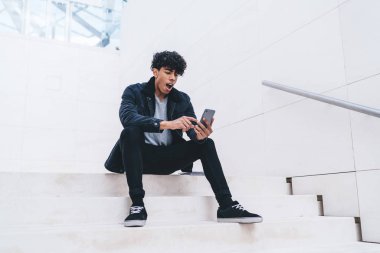 Moda kıyafetli hippi adam, cep telefonu uyarısı ile ilgili hayret verici bir mesaj aldı. Cep telefonu faturası için cep telefonu uygulaması kullanıyor.