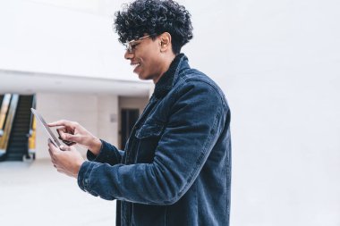 4G kablosuz, genç ve başarılı bir adamın dijital tablet üzerinde arkadaşlarıyla sohbet ederek internet sitesinde gerekli bilgileri aramasının yan görünümü