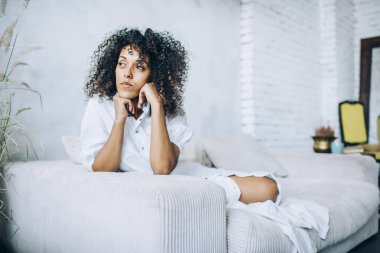 Kanepede oturan düşünceli bir kadın.