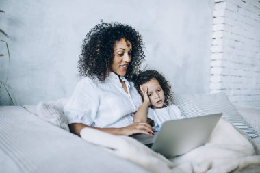 Dizüstü bilgisayarını izleyen mutlu bir kadın.