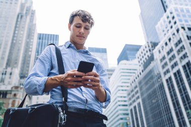 Evrak çantasıyla akıllı erkek hukukçu. Şehir merkezinde internet ve sörf yapan iş adamlarından gelen e-posta bilgilerini kontrol ediyor. Modern teknoloji kavramı.