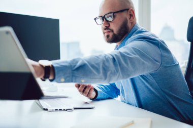 Bilgisayar masasında tablet kullanan modern bir adam