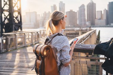 Sırt çantalı uluslararası turistin Brooklyn bölgesinde New York - ABD megalopolis 'i keşfe çıktığı ve büyük şehir alanının manzarasına baktığı manzaranın keyfini çıkardığı bir manzara.