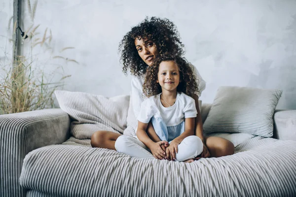 Mulher bonita com menina posando no sofá — Fotografia de Stock