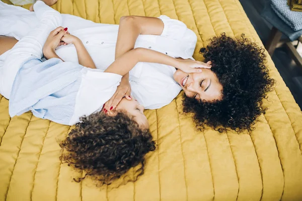 Liebevolle Mutter mit Tochter im Bett — Stockfoto