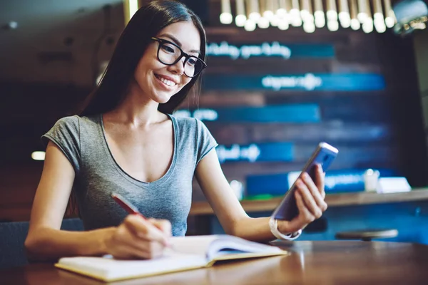 Mutlu kız öğrenci cep telefonuyla internete göz atarken filmin galası hakkında olumlu haberler okuyor, gülümseyen hippi kız gelecekteki seyahatini planlarken ve uygulamayla otel rezervasyonu yaparken eğleniyor.