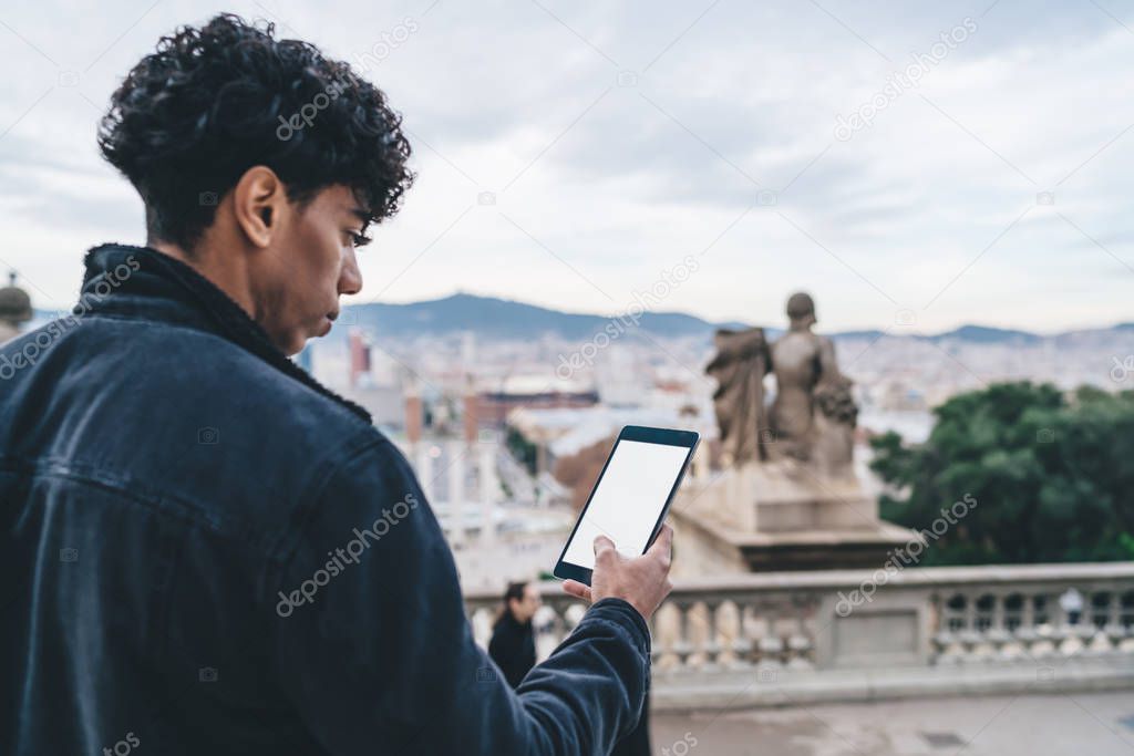 Handsome hipster guy tracking gps via location application on modern digital tablet with copy space area for website for travelers, millennial man chatting via blank touch pad during Spanish vacations