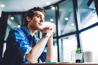 Laptop bilgisayarı olan düşünceli genç hippi, kablosuz internet üzerinden cihaz için yazılım güncelleme üzerine kafa yoruyor. Kafe içinde uzaktan çalışan düşünceli erkek serbest yazar.