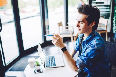 Yetenekli genç adam internet sitesinden gelen bilgilere yoğunlaştı. Kahve masasında oturuyordu ve video izlemek için ücretsiz kablosuz internet bağlantısı kullanıyordu. Mesafe konsepti