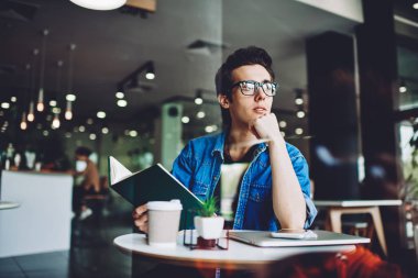 Gözlüklü, vizyon düzeltmesi için gözlüklü, düşünceli genç hippi, kafenin içinde boş zamanlarında düşünceli bakışlar atıyor ve edebiyat kitaplarının en çok satan kitabından ilginç senaryolar üzerinde kafa yoruyor.