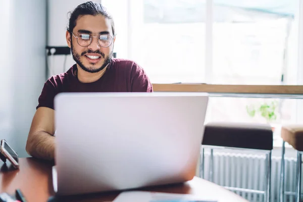 Lachende casual student met behulp van laptop — Stockfoto