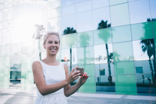 Lachende vrouw met mobiele telefoon op straat — Stockfoto