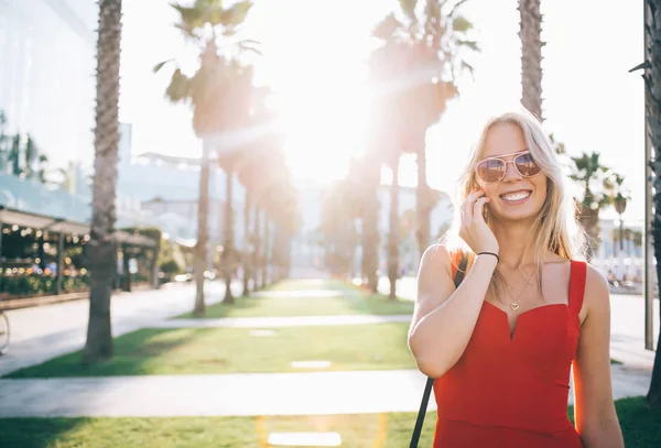 Mujer de moda alegre que habla por teléfono bajo el sol — Foto de Stock