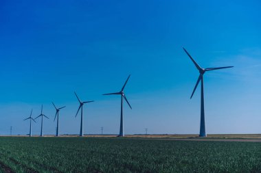 Kırsal alandaki büyük metal yel değirmeni rüzgar esintisiyle kaplı. Bu da doğadan gelen temiz ekolojik alternatif gücü kanıtlıyor. Alternatif elektrik üretimi 