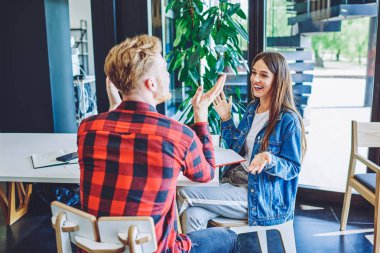 Mutlu gülümseyen arkadaşlar, boş zamanlarında kafenin içinde canlı iletişimin keyfini çıkarıyorlar, modaya uygun giyinmiş başarılı kadın ve erkek, proje fikirleri tartışıyor ve tanıtım alanında konuşuyorlar.