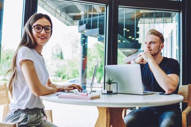 Yetenekli erkek ve kadın birlikte çalışma alanında çalışan profesyoneller dizüstü bilgisayarlarla birlikte otururlar ve ücretsiz internete bağlanırlar, beyaz öğrenciler öğrenmek için zaman harcarlar.