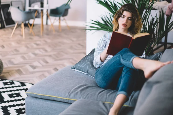 Düşünceli Beyaz Kadın Rahat Bir Kanepede Uzanıp Kitap Okuyan Hippi — Stok fotoğraf