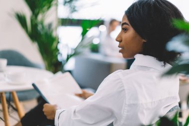 Düşünceli, koyu tenli, elinde kağıtlarla oturan ve boş zamanlarını düşünürken gözlerini kaçıran, Afro-Amerikan hippi kızın düşünceli apartman dairesinde...