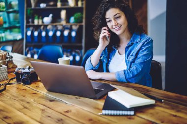 Mutlu amatör fotoğrafçı eski moda fotoğraf makinesiyle ilgili detayları tartışırken laptoptaki uygulamadan gelen e-postayı okurken çalışanla iletişimden keyif alıyor.
