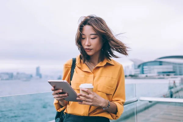 漂亮的日本嬉皮士学生校验收到了站在城市环境下的现代触摸板上的通知 并使用公共网络连接进行安装 千禧年妇女测试程序 — 图库照片