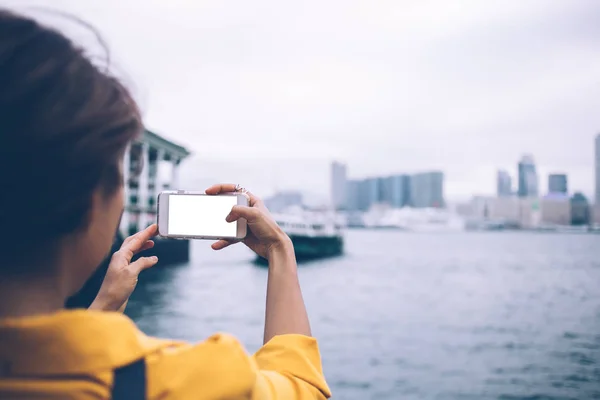 広告テキストのためのモックアップ画面と空白の携帯電話アプリケーションを使用して香港市内のビクトリアベイの千年紀の女性観光客のクリック写真のバックビュー 女性の風景写真 — ストック写真