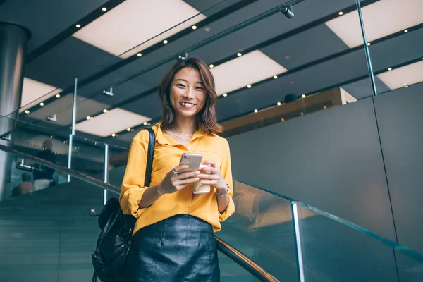 Cep telefonu cihazı olan güzel hippi kızın yarım boy portresi evde durduğu ve neşeli Asyalı bir kadının akıllı telefon aracılığıyla online iletişim sırasında mutluluğu hissettiği için.