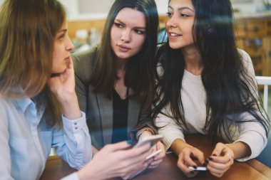 Yayınların çevrimdışı olması için mobil başvuruda bulunan beyaz kadın blogcular, iletişim için boş zamanlarında reklam alanında konuşan çekici genç bayan arkadaşlar.