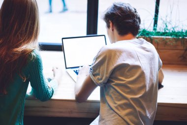 Erkek öğrencilerin, kız arkadaşlarıyla boş zamanlarında dizüstü bilgisayardan öğrenme dili için çevrimiçi kurslar ararken arka plan görüntüsü, reklam için ekran görüntüsü oluşturan netbook