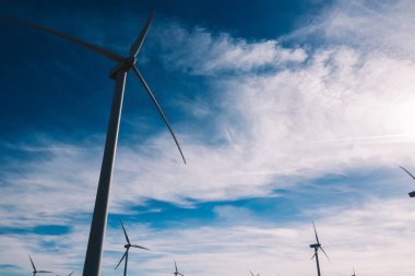 Türbin pervaneleri rüzgar enerjisinden dönen temiz eko enerji üreten ve iklim değişikliğine doğal kaynakları tasarrufu gelen görünümü aşağıda. Dostu teknoloji ile alternatif elektrik üretimi 