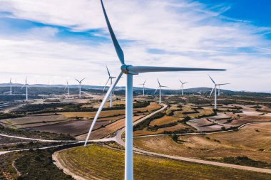 Türbin ve pervaneler ile yel değirmenlerinin havadan görünümü, tarımsal kırsal alanlar alanında Rüzgar elektrik istasyonları ve sistemleri için yeşil enerji üretiyor. Alternatif enerji üretimi 