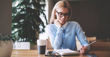 Optik gözlük mutlu kadın öğrenci üniversite kampüsünde öğrenme heyecanlı duygu, pozitif hipster kız tasarım çizimler için fikirler hakkında düşünme ders kitabında örnekler bakıyor