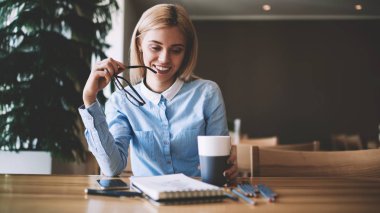 Olumlu kadın tasarımcı ders kitabında skeçler bakıyor ve iyi bitmiş iş hissi, başarılı gülümseyen hipster kız üniversite sınıf odasında otodidakt için zaman harcamak zevk