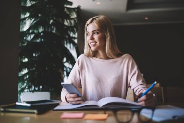 Sınıf içinde üniversite başlangıç projesi üzerinde çalışma break uzak seyir mutlu kadın öğrenci, olumlu hipster kız eğitim molası zevk kapalı öğrenme için Smartphone Gadget kullanarak