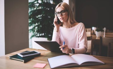 Mimari Proje ve yeni skeçler, konuşma kapalı yapmak için mobil uygulama kullanarak ciddi hipster kız hakkında Detayları tartışmak için meslektaşım çağıran gözlük konsantre kadın