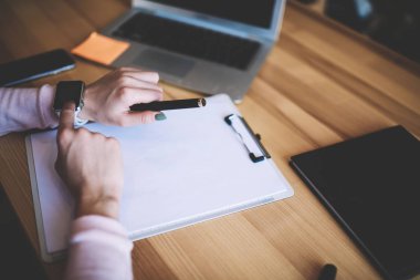 Boş sayfalarda hafta planlama sırasında giyilebilir elektronik SmartWatch üzerinde kadın el kontrol bildirimi kırpılmış görüntü, modern kol dokunmatik ekrana işaret kadın seçici odaklama