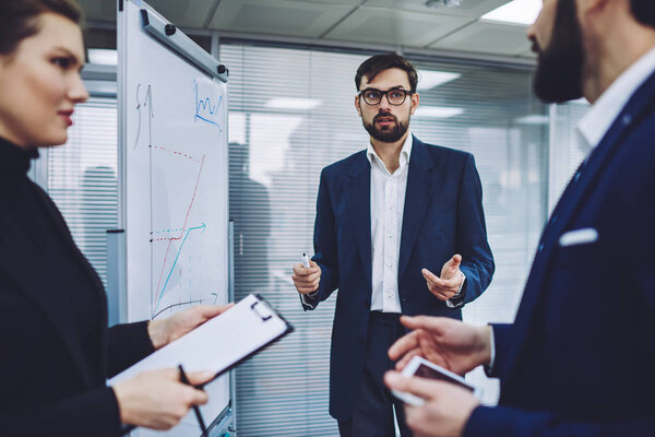 Руководители мужского и женского пола, одетые в офисную форму, обсуждают детали нового проекта для консультантов, беседуют серьезные деловые люди.