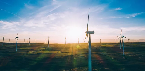 オレンジ色の夕日の空の上に農村農地のアグリ牧草地に立って回転プロペラを持つ近代的な風車 クリーンな資源のための再生可能エネルギーを発生させる風 電力生産 — ストック写真