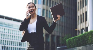 Heyecanlı kadın girişimci cep telefonu ile arayan ortakları ile başlangıç iş projesinin ayrıntılarını tartıştıktan sonra heyecanlı hissediyorum. Başarılı hayran işkadını iş başarısı kutluyor