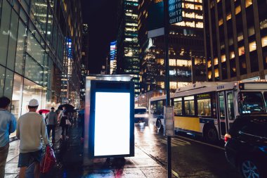 Reklam veya promosyon içeriği için boş kopya boşluk ekranı ile yağmurlu gece otobüs terminali Billboard, bilgi için lightbox kadar boş sahte, uzun pozlama ile kentsel şehir sokakta boş ekran
