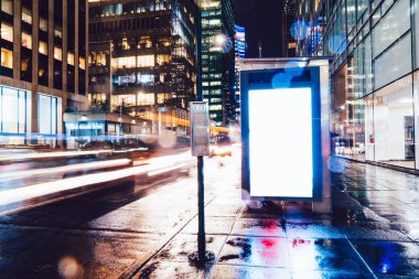 Reklam veya promosyon içeriği için boş kopya boşluk ekranı ile yağmurlu gece otobüs terminali Billboard, bilgi için lightbox kadar boş sahte, uzun pozlama ile kentsel şehir sokakta boş ekran