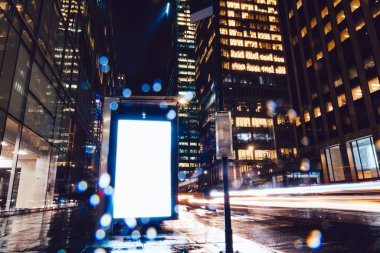 Reklam veya promosyon içeriği için boş kopya boşluk ekranı ile yağmurlu gece otobüs terminali Billboard, bilgi için lightbox kadar boş sahte, uzun pozlama ile kentsel şehir sokakta boş ekran