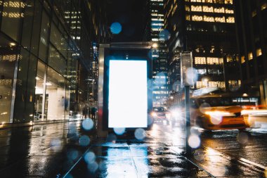 Reklam veya promosyon içeriği için boş kopya boşluk ekranı ile yağmurlu gece otobüs terminali Billboard, bilgi için lightbox kadar boş sahte, uzun pozlama ile kentsel şehir sokakta boş ekran