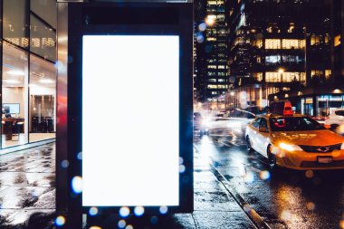 Reklam veya promosyon içeriği için boş kopya boşluk ekranı ile yağmurlu gece otobüs terminali Billboard, bilgi için lightbox kadar boş sahte, uzun pozlama ile kentsel şehir sokakta boş ekran