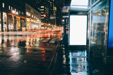 Reklam veya promosyon içeriği için boş kopya boşluk ekranı ile yağmurlu gece otobüs terminali Billboard, bilgi için lightbox kadar boş sahte, uzun pozlama ile kentsel şehir sokakta boş ekran